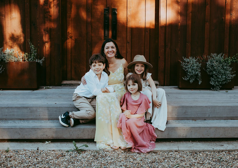 Azur Wines proprietor, Elan Fayard, sitting on a set of steps with her children | Women Owned Wineries